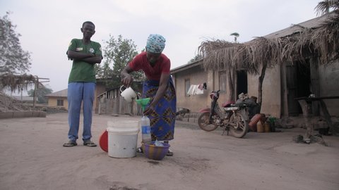 24th March 2021, Lagos Nigeria: African woman selling kerosene to her village customer 