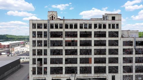 Cincinnati, Ohio - USA: May 14 2021: 4K aerial drone footage of abandoned Crosley Factory on the west side of Cincinnati, Ohio. Cinematic side-tracking shot of windows into aerial spin-around building
