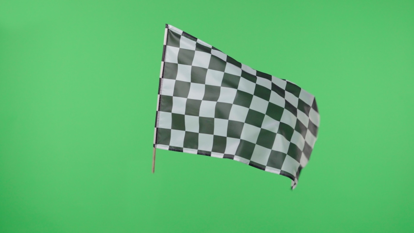 Racing flag silk fabric fluttering against a green screen background. Checkered flag formula one car motor sport. Official finish start race. Racing flag waving. Slow motion. Royalty-Free Stock Footage #1072437755