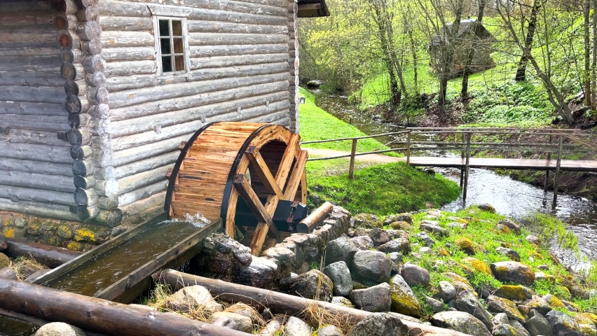 Historic grist mill with a working water wheel, spring summer time, no people. 