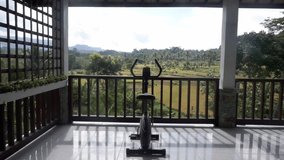 Video footage of exercise bike on the terrace with stunning views of the rice fields and palm trees in Bali
