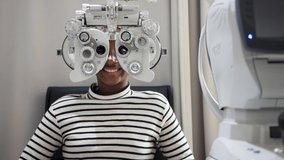 African teen girl Doing Eye Test On Phoropter, African teen girl checking on her eye with optometry machine. - Powered by Shutterstock - Get 15% off with code: PIKWIZARD15