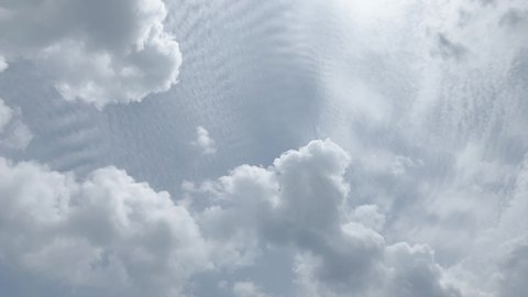 Time-lapse footage of cumulus clouds slowly moving and spreading at low altitude, altocumulus clouds covering the sky up high in the back. Not color graded footage. Japan.