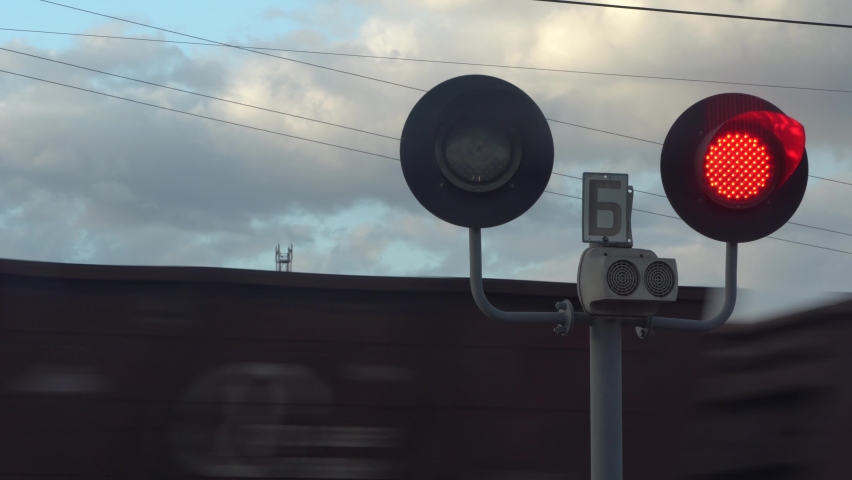 The railway traffic light is red. Stop signal for a stop at a railway crossing. the movement of the train at high speed on the railway tracks. Forbidding traffic light signal Royalty-Free Stock Footage #1072445234
