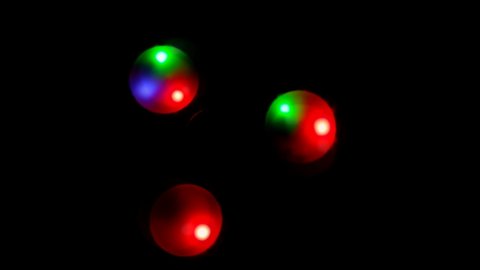 Abstract blurred multicolored glare from the backlight of a fidget spinner. Spinning spinner with LED light. Toy spinner to relax.