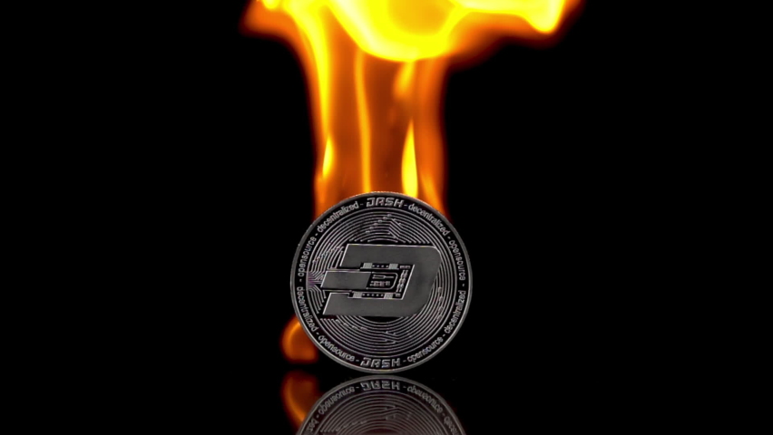 Dash coin catches fire on an isolated black background. Slow motion 250fps.