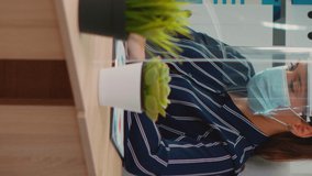Disabled businessman sitting in wheelchair wearing face protection in prevention for coronavirus cleaning hands before checking financial data in business office. Freelancer respecting social distance - Powered by Shutterstock - Get 15% off with code: PIKWIZARD15
