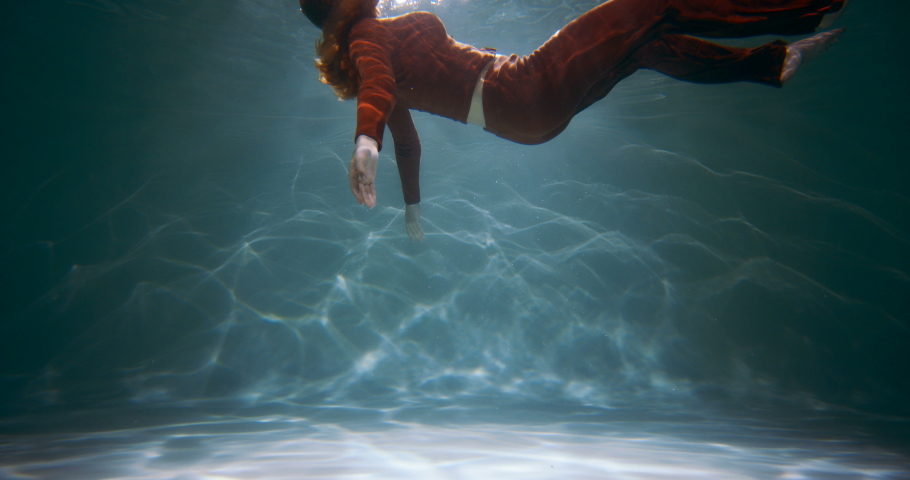 Cinematic side view of young beautiful woman slowly sinking deep under water. Depression, loneliness concept slow motion | Shutterstock HD Video #1072466585