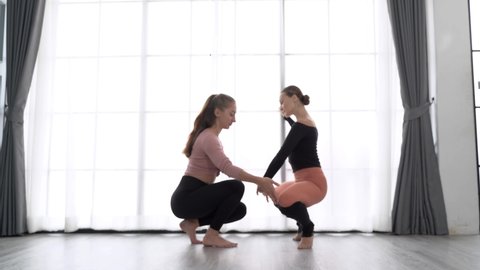 Beautiful woman learning dancing ballet pose with female instructor in performance dance studio. warm up exercise activity, gymnastics or ballet dancing class, or healthy people lifestyle concept.