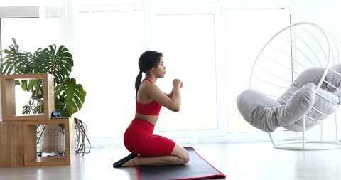 Sporty young black woman making lunges training at home. Athletic fit girl doing fitness aerobic exercises for booty in living room. Home fitness and wellness concept.