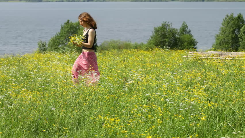 Girl pick up field flower at the meadow 