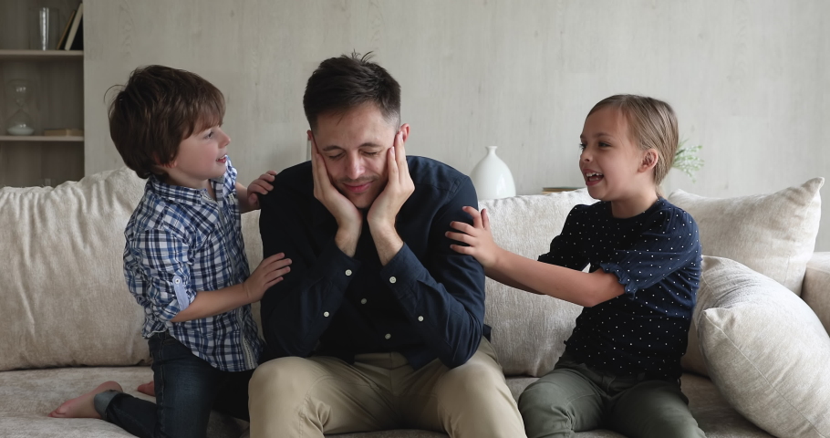 Hyperactive son daughter want to play with tired fatigued father sit on sofa feels exhausted to spend time with kids. Upbringing problem, hyperactivity, divorced helpless parent in depression concept Royalty-Free Stock Footage #1072488899
