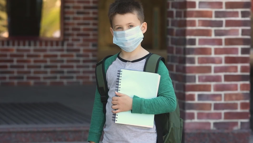 
Lifestyle portrait of a little boy takes off the mask from his face after school. Cute kid wearing backpack and protective mask, ready to study with new normal. The end of lockdown pandemiс covid-19 Royalty-Free Stock Footage #1072493030