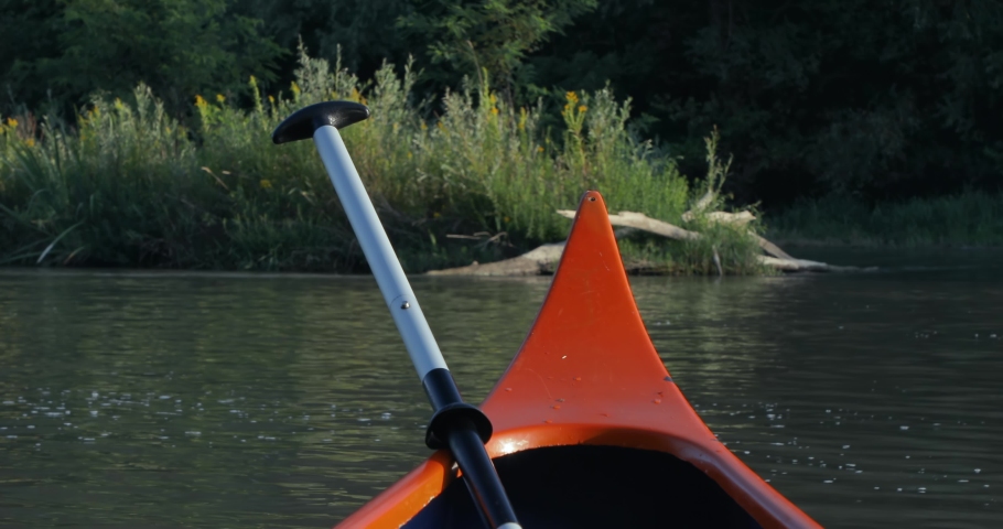 Canoeing in a beautiful natural environment, sunlight reflections, floating down with river current downstream