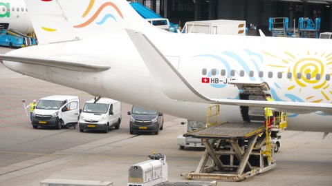 AMSTERDAM, THE NETHERLANDS - JULY 29, 2017: TUI Fly Boeing 767 HB-JJF arrived at the airport, Schiphol Airport, Amsterdam, Holland. Airport staff unload luggage on the plane