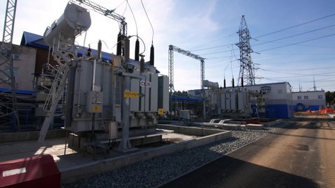 ZELENODOLSK , RUSSIA - JULY 17 2020: Powerful transformer with insulators and equipment at contemporary electrical distribution substation on sunny spring day on July 17 in Zelenodolsk