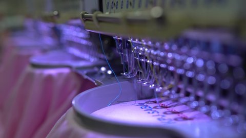 Embroidery machine in progress embroidery company logo on uniform in Textile Industry at Garment Manufacturers.