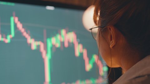 Closeup - Woman is checking Bitcoin price chart on digital exchange on computer, cryptocurrency future price action prediction.