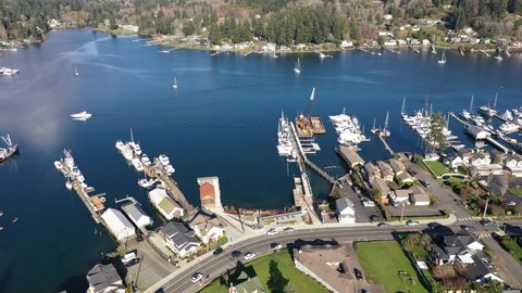 Cinematic panoramic trucking aerial drone footage of the West Shore Marina of Gig Harbor, a quaint, historic, charming tourist destination in the Pacific Northwest, near Tacoma, Washington