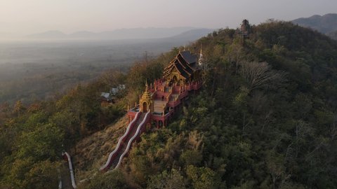rotate aerial shots of temple on the mountain among with nature and foggy sky