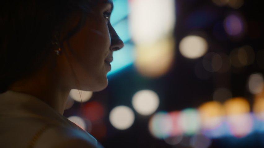 Beautiful Young Woman Walking Through Night City Street Full of Neon Lights and Entertainment Venues. Smiling Attractive Thoughtful Independent Woman Traveling . Arc View Tracking Close-up Shot