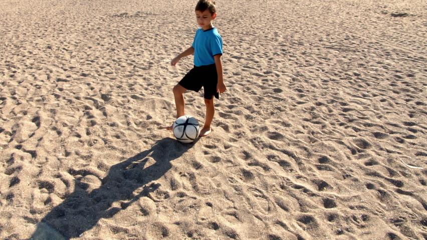 Football soccer game on the beach. Little boy playing with a ball on the sea beach, 4k slow motion | Shutterstock HD Video #1072531205
