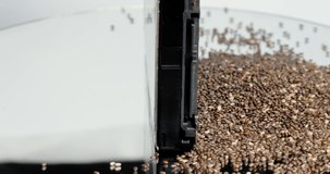 On a rotating table is a hard drive and a pile of chia seeds. This video can be used as a display of the chia crypto coin. High quality 4K footage