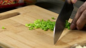 Cutting chives into smaller pieces. Asian food preparing a meal.