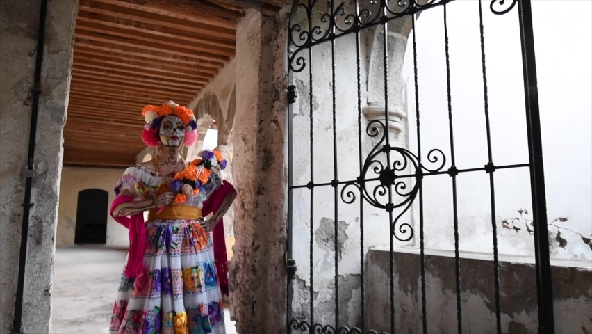 Catrina woman walking in old house with flowers on her head