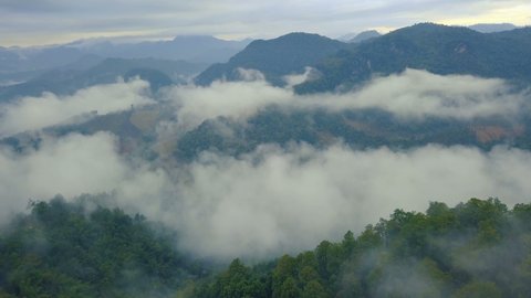 Aerial View. Flying over the high mountains forest with village in beautiful clouds fog, at Doi luang Chiang dao, Chiang mai, Thailand.
