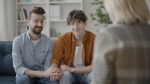 Gay couple talking to psychologist, family undergoing therapy to save marriage