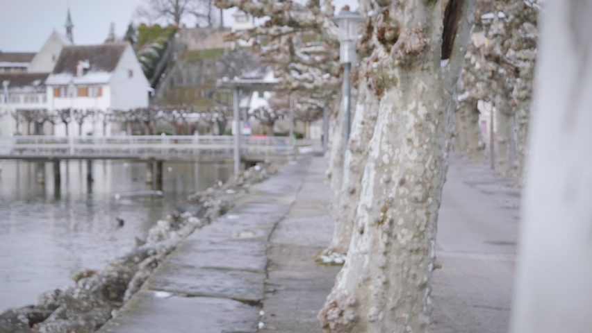 Young female model taking selfies on vacation in small wintry town on the bank of a river. Digital selfie text overlay.