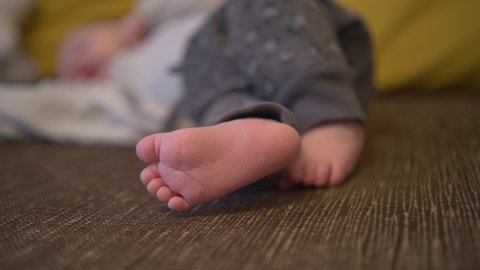 Close-up shot of a newborn barefoot isolated with a blurred background,ing while he sleep, static shot