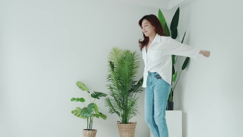 Smiling woman and white shirt dancing with feelgood emotion in the white room
