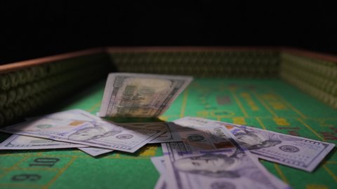 Los Angeles, CA USA - May 11 2021: This slow motion video shows hundred dollar bills falling on a craps table.
