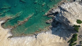 Aerial video view from drone on underwater reefs and coastal rocks in mediterranean sea near Kalo Horafi and Vrahi beaches with clear transparent water. Camera looks down. Crete, Greece.