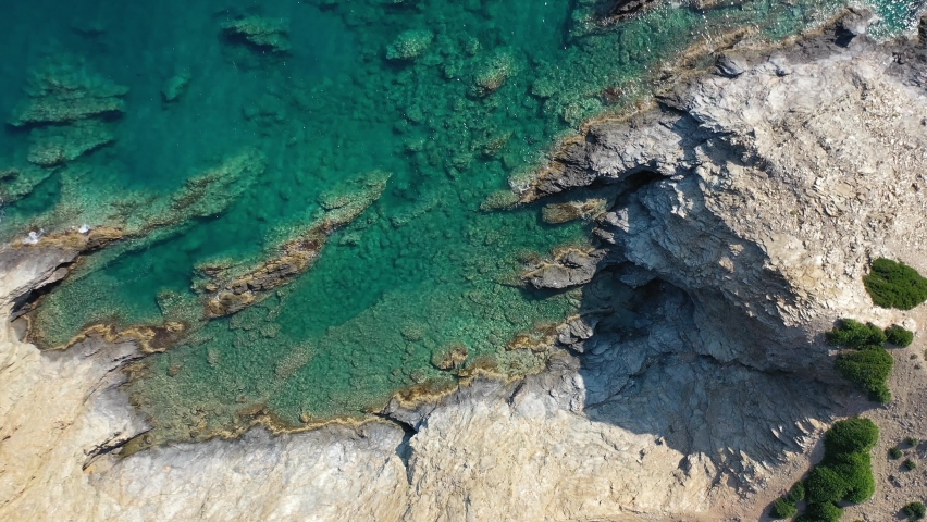 Aerial video view from drone on underwater reefs and coastal rocks in mediterranean sea near Kalo Horafi and Vrahi beaches with clear transparent water. Camera looks down. Crete, Greece. | Shutterstock HD Video #1072577540
