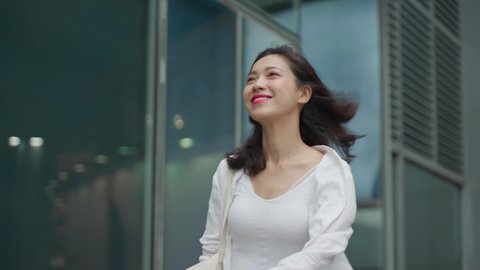4k slow motion side view tracking shot of pretty young asian woman walking in the urban Chengdu City street with confidence smile