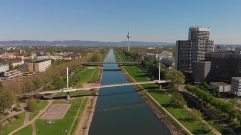 Top view of the embankment of the Neckar River. Bridges, TV tower, green grass and trees. Hospital, tram lines. Mannheim. Germany.
