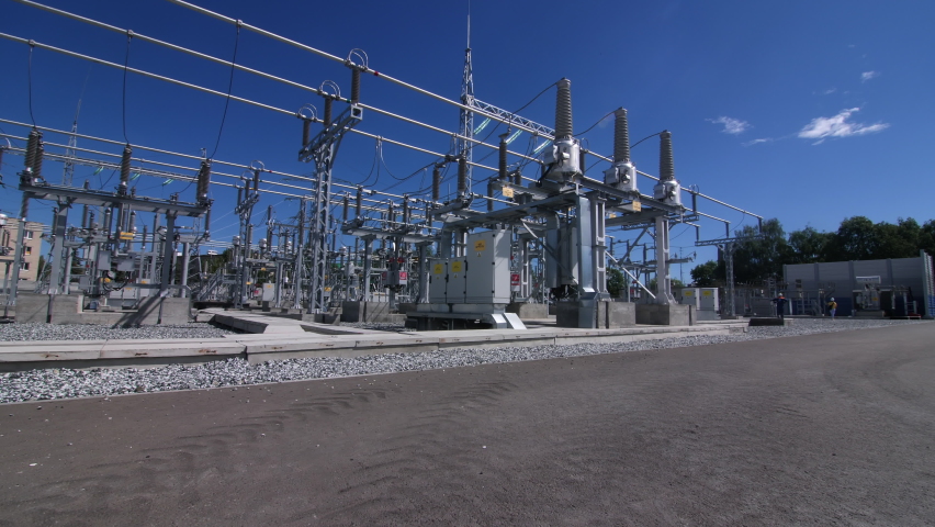 Supports with insulators and transformers at modern electrical distribution substation against blue sky close view Royalty-Free Stock Footage #1072581956