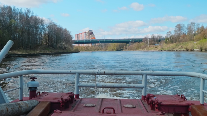 View of water traces left by tug sailing on river. Spring nature in Russia