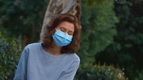 [Camera Used: Canon C300] Caucasian woman wearing a surgical face mask and smiling while outside. For more variations of this clip in the same series, check out this seller's other videos.