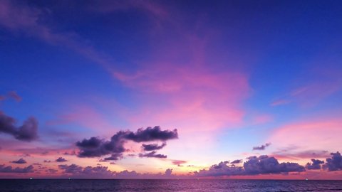 Colorful red purple pink sunset cloud n evening dark grey cloudscape on beautiful twilight sky background over deep blue sea water surface n calm ocean wave ripple, Slow Motion 4k b-roll footage video