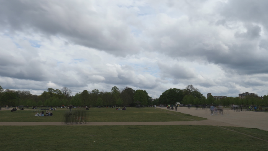 Time lapse. Heavy clouds moving over a busy park.