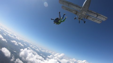Skydiving. Tandem jump. A preety woman and her instructor are in the amazing sky.