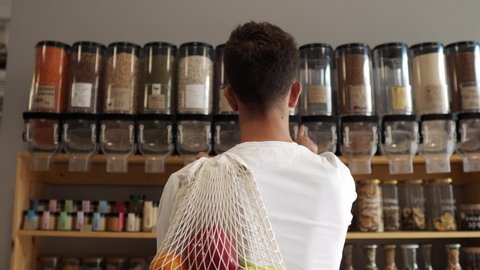Man in a mindful consumption store without packaging with pasta, nuts or grains in a store without plastic waste. Low-waste lifestyle. Sustainable ecological lifestyle. Eco shop 스톡 비디오