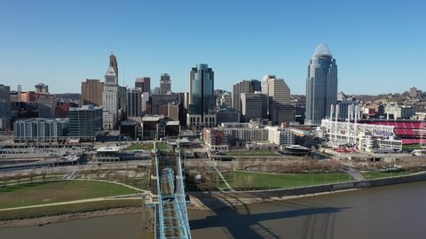Cincinnati, Ohio, USA - April 19 2021: 4K aerial drone shot above the John A. Roebling Suspension Bridge in Downtown Cincinnati. Shot from the Covington side of the Ohio River. Dolly left to right.