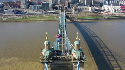 Cincinnati, Ohio, USA - April 19 2021: 4K aerial drone shot above the John A. Roebling Suspension Bridge in Downtown Cincinnati. Shot from the Covington side of the Ohio River. Dolly forward.