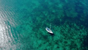 Aerial view of a medium-sized yacht in the bay. Yacht sailing on the open sea on a sunny day. Boating in the Black Sea. Sailing aerial 4k video footage.