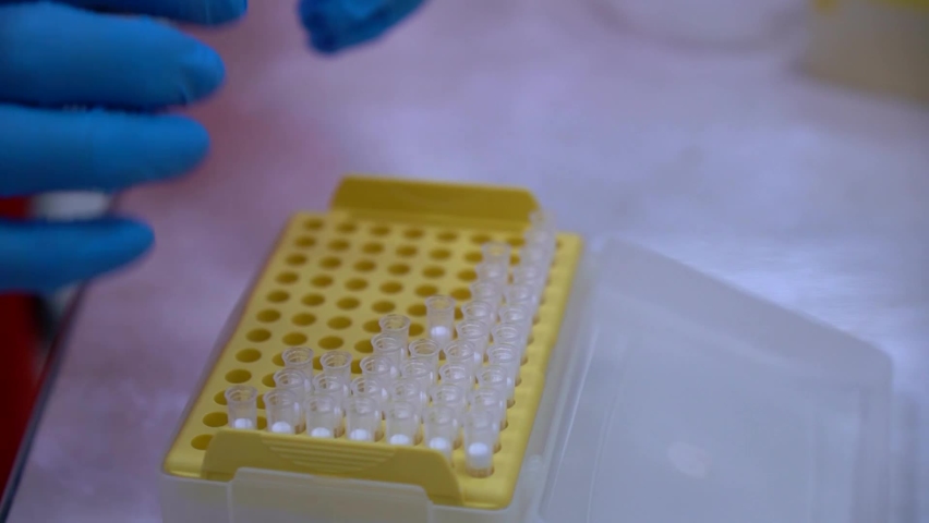 laboratory of coronavirus and other infections, puts ampoules in a box in an orange protective suit and blue gloves for further processing, a Healthcare Video by Khavazhi Akhmadov